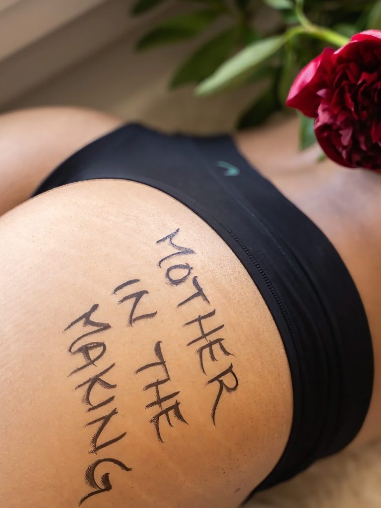 Close-up of a thigh with "Mother in the Making" written on it, adorned with a rose. boudoir in altoona pennsylvania, zxr photography, gary t